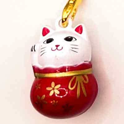 3D-Anhänger in der Form eines roten Beutels mit goldenen Blumendetails. Daraus schaut eine weiße Katze mit dem Kopf hervor, die winkt und lächelt.