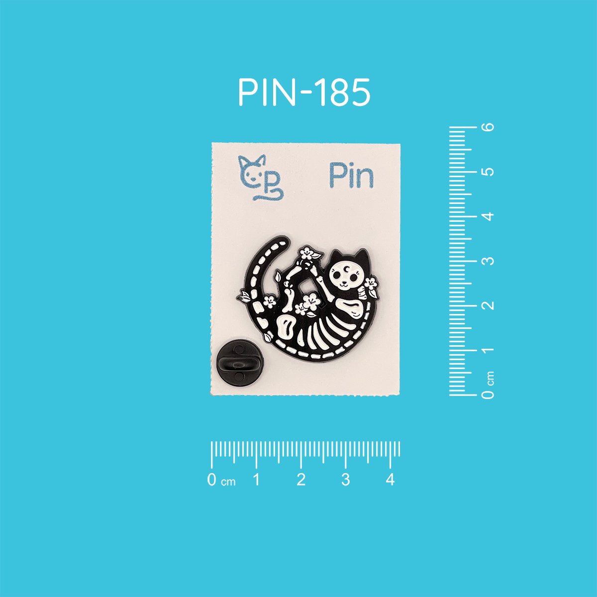 Pin mit dem Motiv einer eingerollten schwarzen Katze, in welcher man ihr Skelett erkennen kann, als sei sie mit einem Röntgenstrahl getroffen worden. Um sie herum befinden sich weiße Blumendetails.