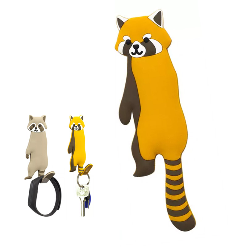 WG-22-007-rotPanda Große Abbildung eines Silikonhakens in der Form eines orange-braunen Waschbären. Daneben sind noch 2 Haken aus der Entfernung abgebildet, die verschiedene kleine Gegenstände tragen.