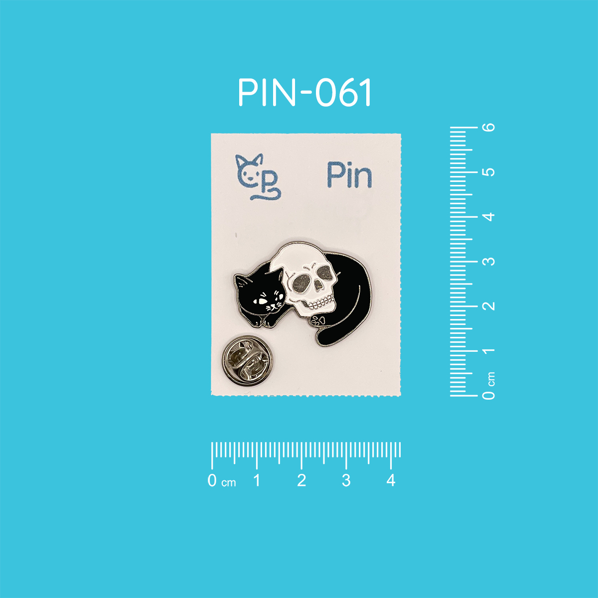 Pin mit dem Motiv einer liegenden schwarzen Katze, die sich um einen Schädel drapiert hat.