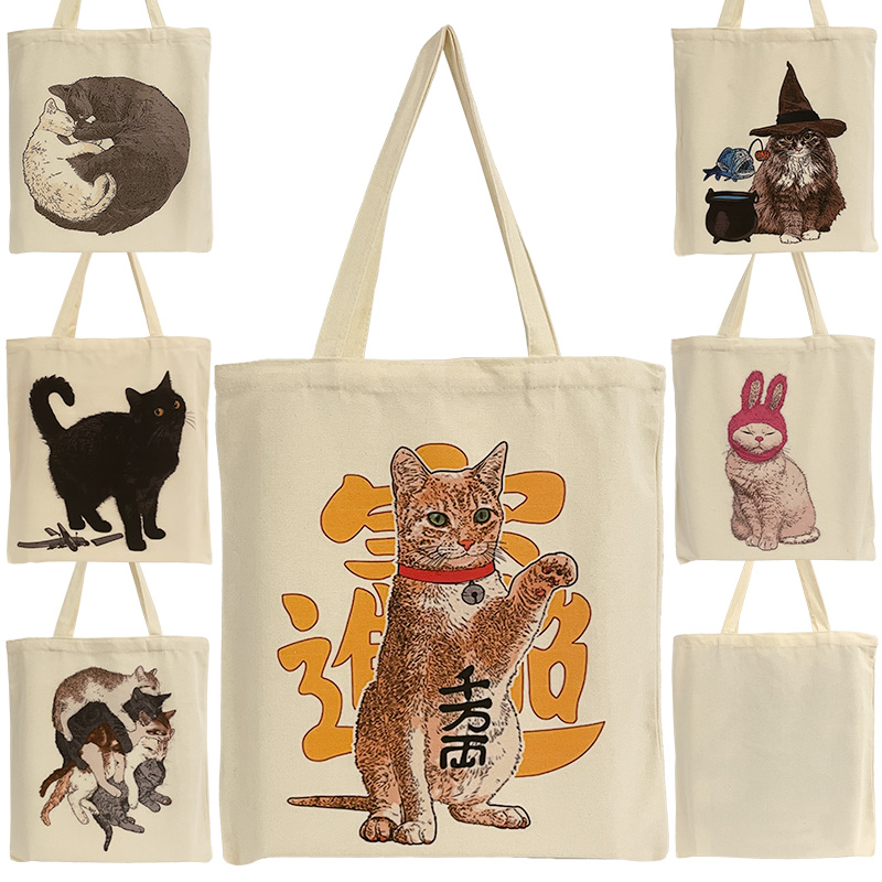 ES-22-001-ALLZ4Y5FWAUkffrC 6 Baumwoll-Einkaufstaschen mit verschiedenen Katzenmotiven und eine Abbildung der Rückansicht der Taschen.