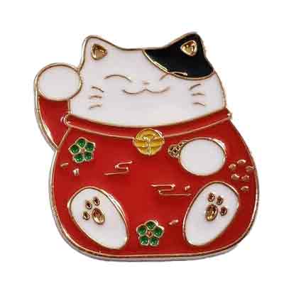 Goldener Anhänger in der Form einer dicken schwarz-weißen Katze mit Blumen auf ihrem Körper und einem roten Halsband mit goldenem Glöckchen.