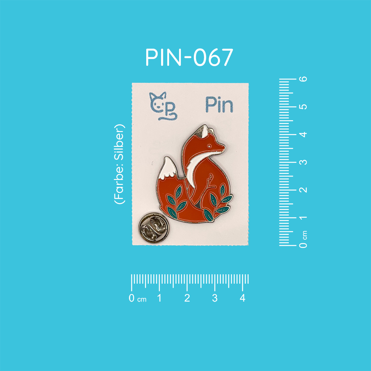 Silberner Pin mit dem Motiv eines sitzenden roten Fuchses. Vor ihm wachsen zwei Blätterranken.