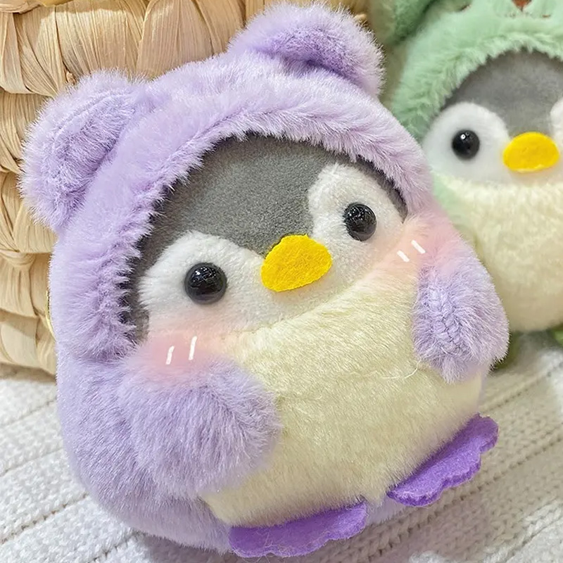 Plüschpinguine-Schlüsselanhänger in lilafarbenem Bärenkostüm.