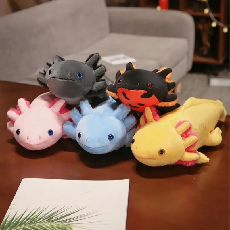 5 Axolotlplüschtiere in den Farben grau, schwarz, gelb, rosa und blau.