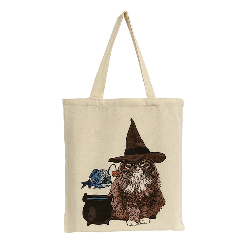 ES-22-001-5 Baumwolltasche mit dem Motiv einer braun-weißen Katzen mit langem Fell und einem Hexenhut. Neben ihr sind ein Kessel und ein schwebender Anglerfisch abgebildet.